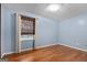 A simple bedroom with hardwood floors and a window covered with curtains at 7972 Woods Lane, Jonesboro, GA 30236