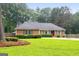 Charming brick home with a well-manicured front yard and mature trees at 7972 Woods Lane, Jonesboro, GA 30236