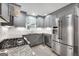 Modern kitchen with stainless steel appliances, granite countertops, and gray cabinetry at 7972 Woods Lane, Jonesboro, GA 30236