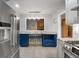 Bright eat-in kitchen features stainless appliances, granite countertop and blue cabinetry at 7972 Woods Lane, Jonesboro, GA 30236