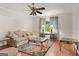Cozy living room featuring a neutral sofa, area rug, and a ceiling fan at 7972 Woods Lane, Jonesboro, GA 30236