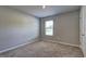 Clean, neutral bedroom with cozy carpet and bright natural light from the window at 237 Cranapple Ln, Mcdonough, GA 30253