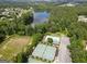 Aerial view featuring a pool, tennis courts, and a serene lake surrounded by lush greenery and homes at 330 Bay Grove Rd, Loganville, GA 30052