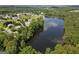 Scenic aerial view of a tranquil lake reflecting the sky, surrounded by trees and established residential homes at 330 Bay Grove Rd, Loganville, GA 30052