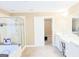 Bright bathroom featuring double vanity, shower, tub, and doorway to the bedroom at 330 Bay Grove Rd, Loganville, GA 30052