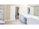 Bright bathroom featuring double vanity, shower, tub, and doorway to the bedroom at 330 Bay Grove Rd, Loganville, GA 30052