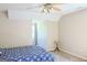 Bright bedroom featuring blue patterned bedding and carpet, filled with natural light at 330 Bay Grove Rd, Loganville, GA 30052