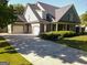 Charming home featuring a three-car garage, a covered porch, and well-maintained landscaping at 330 Bay Grove Rd, Loganville, GA 30052