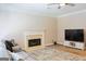 Cozy living room with fireplace, TV, and a sectional couch, perfect for relaxation at 330 Bay Grove Rd, Loganville, GA 30052