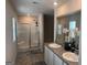 Bathroom with glass-enclosed shower and dual sinks, adorned with elegant floral decor, reflecting modern comfort at 2276 Waycross Ln # 21, Dacula, GA 30019
