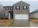 Traditional two-story home featuring a large two-car garage and neutral brick facade at 2276 Waycross Ln # 21, Dacula, GA 30019