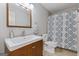 Bathroom with wood vanity, patterned shower curtain, and a large sink at 242 Adair St, Decatur, GA 30030