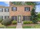 Charming brick townhome with well-maintained landscaping and black shutters on windows at 242 Adair St, Decatur, GA 30030
