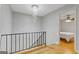 Upstairs hallway featuring hardwood floors, chandelier, and views into a bedroom with ceiling fan at 242 Adair St, Decatur, GA 30030