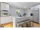 Bright kitchen features white cabinetry, stainless steel appliances, and center island with seating at 242 Adair St, Decatur, GA 30030