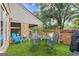 Back patio with artificial grass, table and chairs, and brick wall at 242 Adair St, Decatur, GA 30030