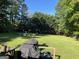 Expansive backyard with lush green grass and mature trees offering a serene outdoor space at 211 Groveland Dr, Peachtree City, GA 30269