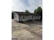 Back exterior of home with gray siding, stone accents, and access to parking area at 5225 Silhouette Sw Ln, Mableton, GA 30126
