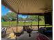 Relaxing back porch with comfortable seating overlooks a large, lush backyard with mature trees at 125 Kayla Ct, Locust Grove, GA 30248
