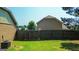 View of the home's fenced back yard with plenty of green grass at 125 Kayla Ct, Locust Grove, GA 30248