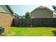 View of the home's fenced back yard with plenty of green grass at 125 Kayla Ct, Locust Grove, GA 30248