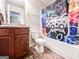 Cozy bathroom featuring tiled floors, wooden vanity and a shower and tub with colorful curtain at 125 Kayla Ct, Locust Grove, GA 30248