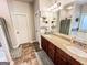 Bathroom featuring double sink vanity with granite countertop, decorative mirror, and tiled flooring at 125 Kayla Ct, Locust Grove, GA 30248