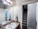 Well-lit bathroom with a mirror, vanity, and view of the staircase at 125 Kayla Ct, Locust Grove, GA 30248