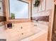 Close up showing a luxurious bathtub with tile surround and window at 125 Kayla Ct, Locust Grove, GA 30248