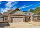Charming brick home boasts a well-manicured lawn and a spacious three-car garage, adding to its curb appeal at 125 Kayla Ct, Locust Grove, GA 30248
