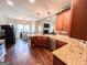 Beautiful kitchen with an island bar, granite countertops, wood cabinetry, and views into the dining and living areas at 125 Kayla Ct, Locust Grove, GA 30248
