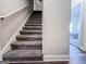 Carpeted staircase with white railing leads to the upper level, bathed in natural light at 125 Kayla Ct, Locust Grove, GA 30248