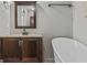 Bathroom with modern soaking tub and dark brown vanity at 3119 Conyers Se St, Covington, GA 30014