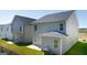 Back exterior of home featuring gray siding, patio and green grass at 11884 Aukerman Way, Hampton, GA 30228