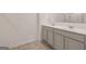Modern bathroom featuring a double sink vanity with gray cabinets and a large mirror at 11884 Aukerman Way, Hampton, GA 30228