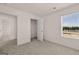 Carpeted bedroom features a large window, a closet, and open doorway to another room at 11884 Aukerman Way, Hampton, GA 30228