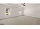 Spacious bedroom with neutral carpet, tray ceiling, and bright natural light from two windows at 11884 Aukerman Way, Hampton, GA 30228