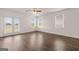 Bright living room with wood floors, ceiling fan, and glass doors with blinds at 11884 Aukerman Way, Hampton, GA 30228
