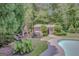 Lush backyard offering a stone fireplace, relaxing seating, and a view of the pool and manicured landscaping at 305 Sherwood Rd, Fayetteville, GA 30215
