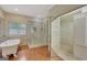 Bathroom featuring hardwood floors, a glass shower, soaking tub, and walk-in closet at 305 Sherwood Rd, Fayetteville, GA 30215