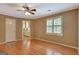 Bright bedroom with hardwood floors, a ceiling fan, and a view of the kitchen through a doorway at 305 Sherwood Rd, Fayetteville, GA 30215