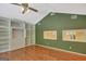Bedroom with hardwood floors, ceiling fan, two windows with view of the yard, and built-in shelving at 305 Sherwood Rd, Fayetteville, GA 30215