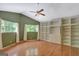 Bedroom with hardwood floors, ceiling fan, two windows with view of the yard, and built-in shelving at 305 Sherwood Rd, Fayetteville, GA 30215