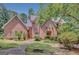 Beautiful brick home featuring a well-manicured lawn, lush landscaping, and a charming walkway to the front entrance at 305 Sherwood Rd, Fayetteville, GA 30215
