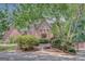 Charming brick home featuring an arched entrance, lush landscaping, and mature trees providing shade and privacy at 305 Sherwood Rd, Fayetteville, GA 30215