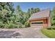 The garage with lush plants and trees in the background, and a long driveway leading to the garage at 305 Sherwood Rd, Fayetteville, GA 30215