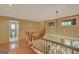 Hallway with hardwood floors, wooden railing staircase, and a view to the bathroom at 305 Sherwood Rd, Fayetteville, GA 30215