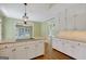 Kitchen featuring a large island with a cooktop, white cabinetry, and hardwood floors throughout the space at 305 Sherwood Rd, Fayetteville, GA 30215
