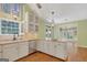 Kitchen area featuring white cabinetry, stainless steel appliances, pendant lighting, and an island cooktop at 305 Sherwood Rd, Fayetteville, GA 30215