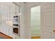 Kitchen area featuring built-in stainless steel appliances and a door leading to a large, organized pantry at 305 Sherwood Rd, Fayetteville, GA 30215